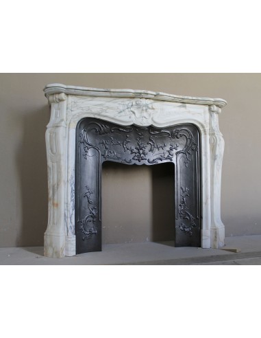 An antique refined Louis XV “Coquille” fireplace mantel in Calacatta Gold marble with its original floral cast-iron insert.