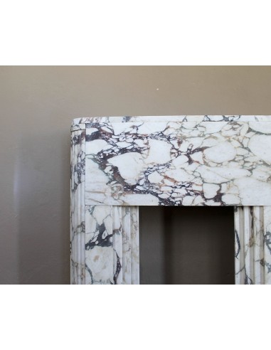 Exceptional Art Deco fireplace mantel in Gold Calacatta Viola marble, featuring violet and gold veins on a white background.