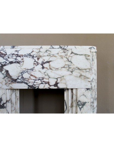 Exceptional Art Deco fireplace mantel in Gold Calacatta Viola marble, featuring violet and gold veins on a white background.