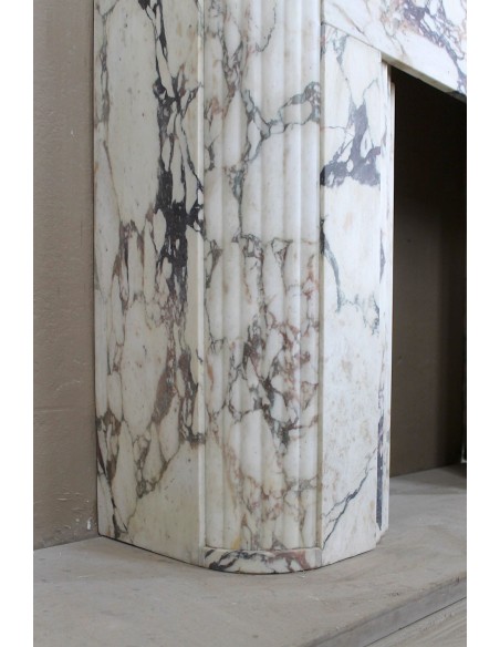 Exceptional Art Deco fireplace mantel in Gold Calacatta Viola marble, featuring violet and gold veins on a white background.