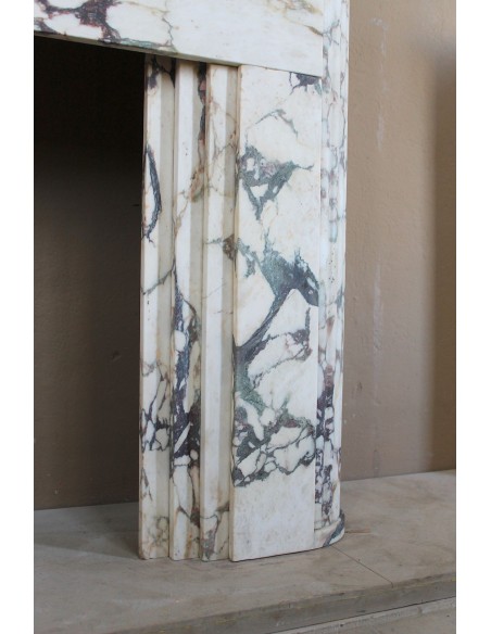 Exceptional Art Deco fireplace mantel in Gold Calacatta Viola marble, featuring violet and gold veins on a white background.