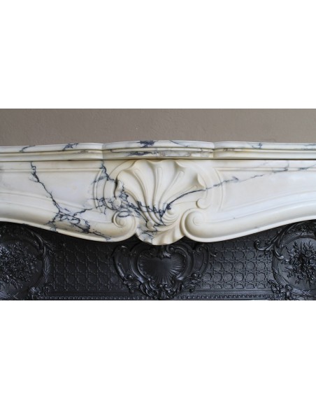 Important antique Louis XV “Coquille Bordelaise” fireplace mantel in rare Pavonazzo marble, with its original cast-iron insert.
