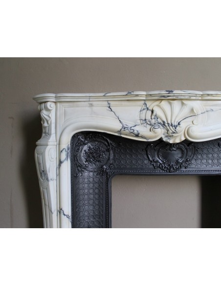 Important antique Louis XV “Coquille Bordelaise” fireplace mantel in rare Pavonazzo marble, with its original cast-iron insert.