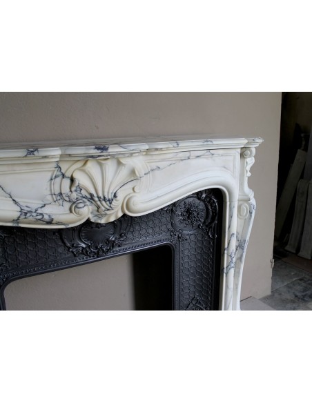 Important antique Louis XV “Coquille Bordelaise” fireplace mantel in rare Pavonazzo marble, with its original cast-iron insert.