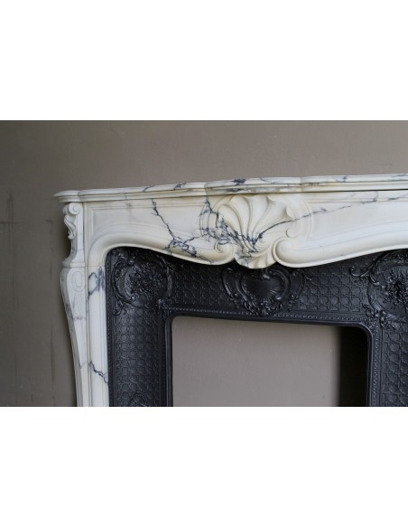 Important antique Louis XV “Coquille Bordelaise” fireplace mantel in rare Pavonazzo marble, with its original cast-iron insert.