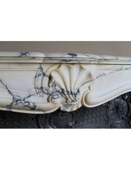 Important antique Louis XV “Coquille Bordelaise” fireplace mantel in rare Pavonazzo marble, with its original cast-iron insert.