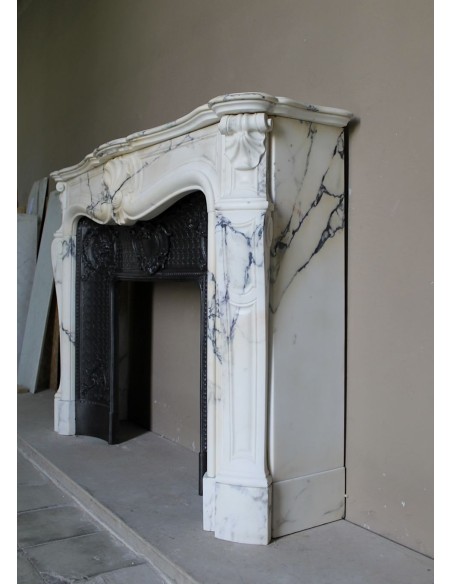 Important antique Louis XV “Coquille Bordelaise” fireplace mantel in rare Pavonazzo marble, with its original cast-iron insert.