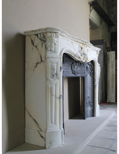 Important antique Louis XV “Coquille Bordelaise” fireplace mantel in rare Pavonazzo marble, with its original cast-iron insert.