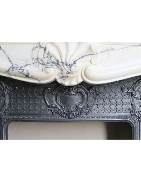 Important antique Louis XV “Coquille Bordelaise” fireplace mantel in rare Pavonazzo marble, with its original cast-iron insert.