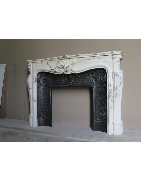 Important antique Louis XV “Coquille Bordelaise” fireplace mantel in rare Pavonazzo marble, with its original cast-iron insert.