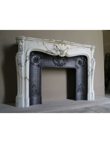 Important antique Louis XV “Coquille Bordelaise” fireplace mantel in rare Pavonazzo marble, with its original cast-iron insert.