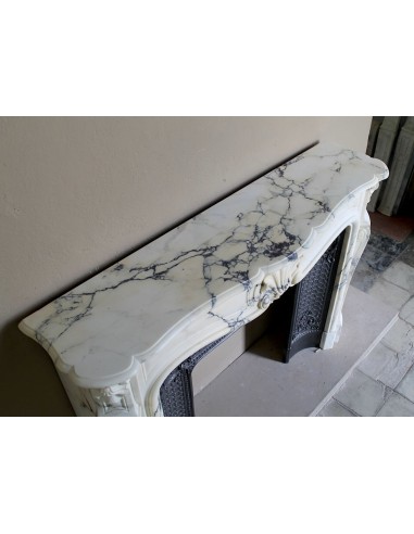 Important antique Louis XV “Coquille Bordelaise” fireplace mantel in rare Pavonazzo marble, with its original cast-iron insert.