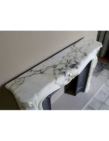 Important antique Louis XV “Coquille Bordelaise” fireplace mantel in rare Pavonazzo marble, with its original cast-iron insert.