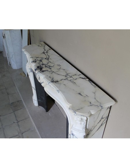 Important antique Louis XV “Coquille Bordelaise” fireplace mantel in rare Pavonazzo marble, with its original cast-iron insert.