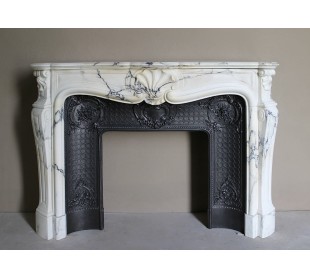 Important antique Louis XV “Coquille Bordelaise” fireplace mantel in rare Pavonazzo marble, with its original cast-iron insert.