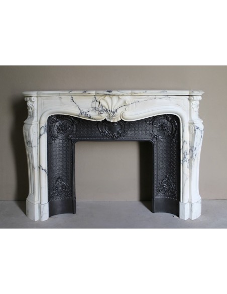 Important antique Louis XV “Coquille Bordelaise” fireplace mantel in rare Pavonazzo marble, with its original cast-iron insert.
