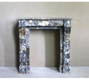Antique “Palmettes” fireplace in a charmingly compact size, carved in Black marble with richly varied multicoloured veining.