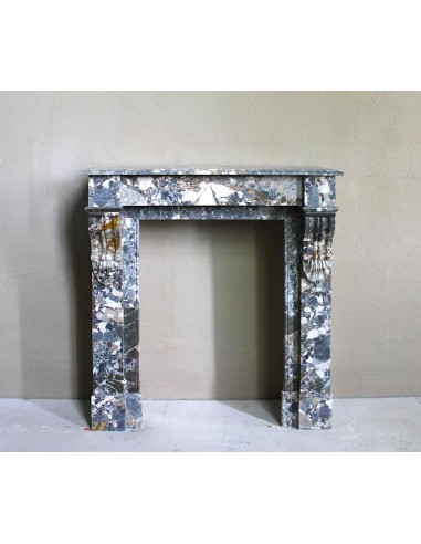 Antique “Palmettes” fireplace in a charmingly compact size, carved in Black marble with richly varied multicoloured veining.