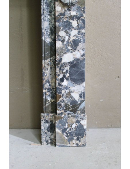 Antique “Palmettes” fireplace in a charmingly compact size, carved in Black marble with richly varied multicoloured veining.