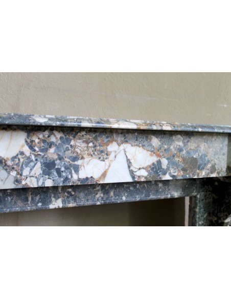 Antique “Palmettes” fireplace in a charmingly compact size, carved in Black marble with richly varied multicoloured veining.