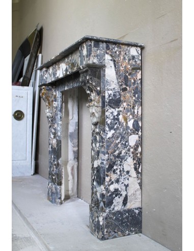Antique “Palmettes” fireplace in a charmingly compact size, carved in Black marble with richly varied multicoloured veining.