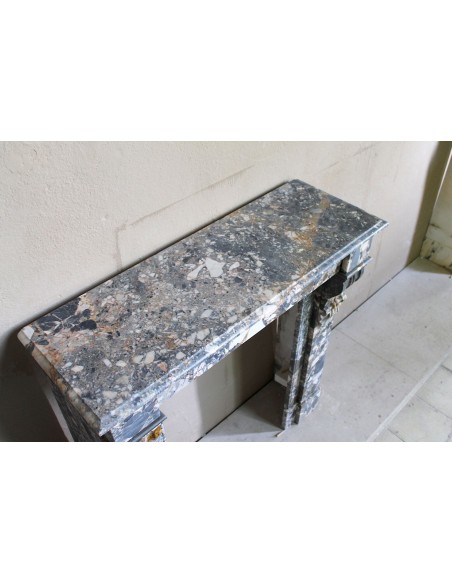 Antique “Palmettes” fireplace in a charmingly compact size, carved in Black marble with richly varied multicoloured veining.