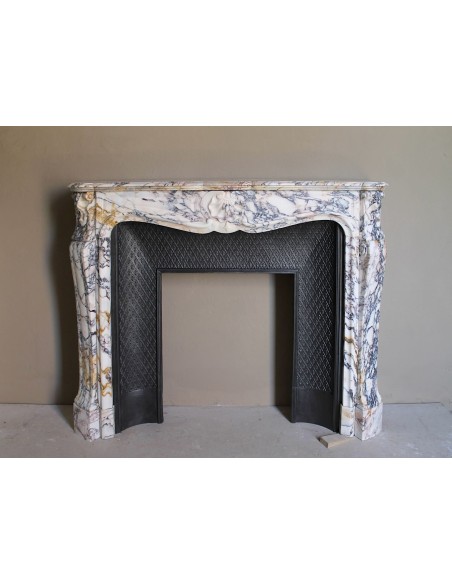 Antique Louis XV fireplace in Calacatta Gold marble with striking gold, violet and pink veining, with original cast-iron insert.