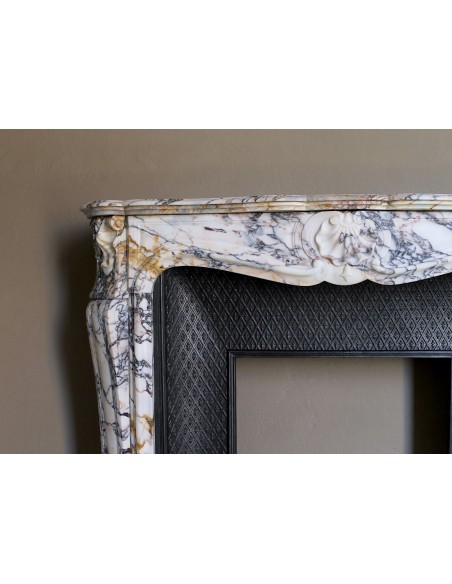 Antique Louis XV fireplace in Calacatta Gold marble with striking gold, violet and pink veining, with original cast-iron insert.