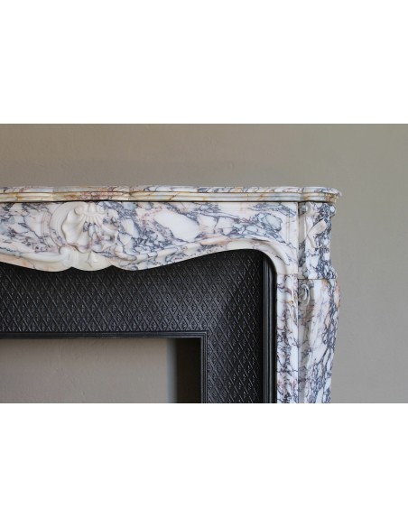 Antique Louis XV fireplace in Calacatta Gold marble with striking gold, violet and pink veining, with original cast-iron insert.