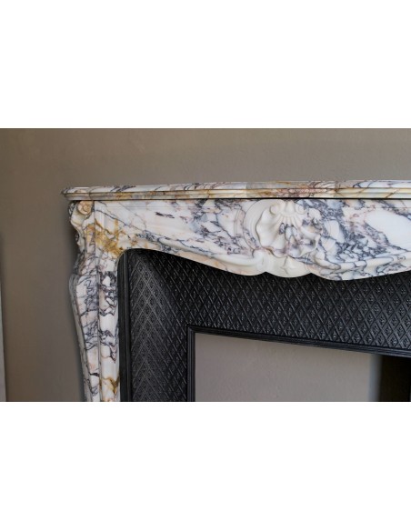 Antique Louis XV fireplace in Calacatta Gold marble with striking gold, violet and pink veining, with original cast-iron insert.