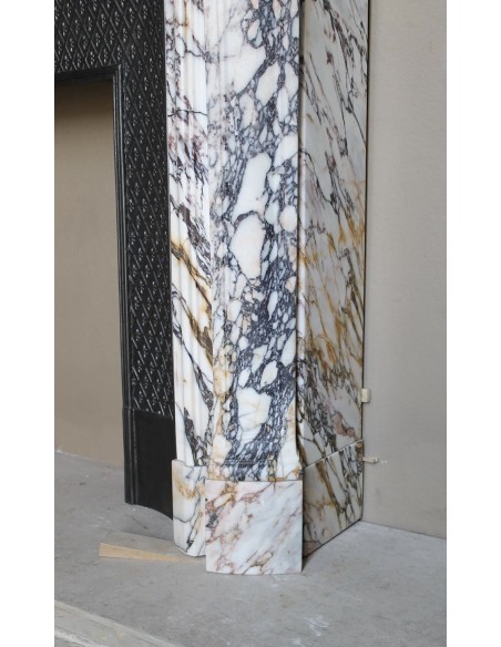 Antique Louis XV fireplace in Calacatta Gold marble with striking gold, violet and pink veining, with original cast-iron insert.