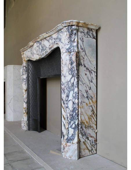 Antique Louis XV fireplace in Calacatta Gold marble with striking gold, violet and pink veining, with original cast-iron insert.