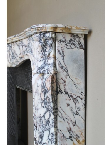 Antique Louis XV fireplace in Calacatta Gold marble with striking gold, violet and pink veining, with original cast-iron insert.