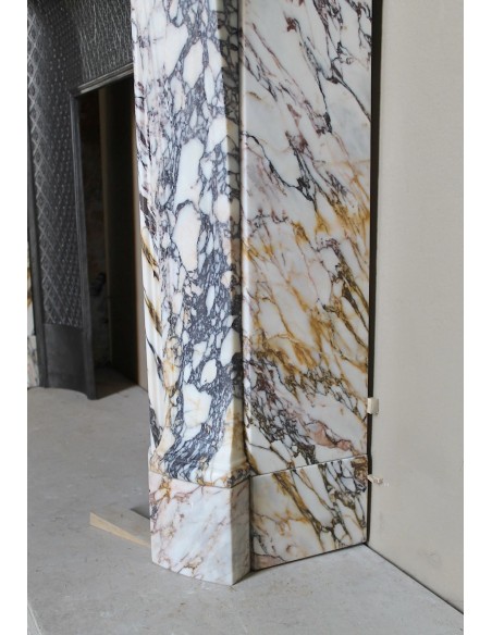 Antique Louis XV fireplace in Calacatta Gold marble with striking gold, violet and pink veining, with original cast-iron insert.