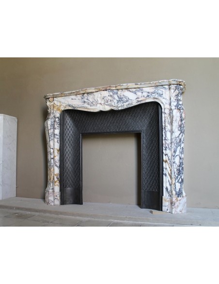Antique Louis XV fireplace in Calacatta Gold marble with striking gold, violet and pink veining, with original cast-iron insert.