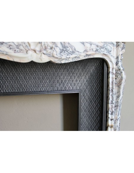 Antique Louis XV fireplace in Calacatta Gold marble with striking gold, violet and pink veining, with original cast-iron insert.