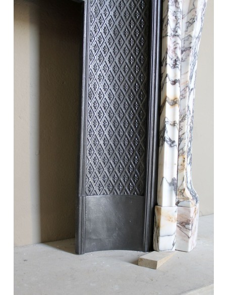 Antique Louis XV fireplace in Calacatta Gold marble with striking gold, violet and pink veining, with original cast-iron insert.