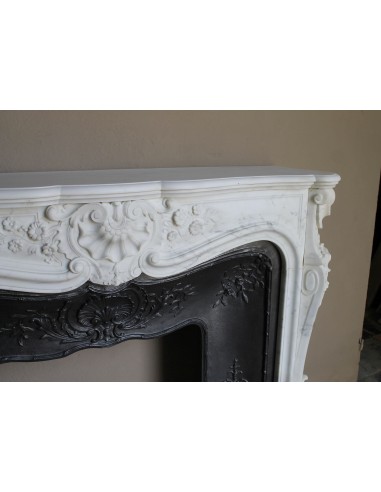 Impressive Baroque antique fireplace in Statuary White marble, featuring elegant floral carvings, and a cast-iron insert.