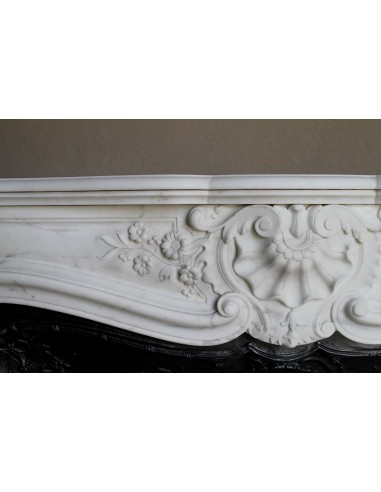 Impressive Baroque antique fireplace in Statuary White marble, featuring elegant floral carvings, and a cast-iron insert.