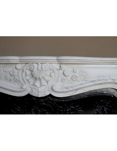 Impressive Baroque antique fireplace in Statuary White marble, featuring elegant floral carvings, and a cast-iron insert.