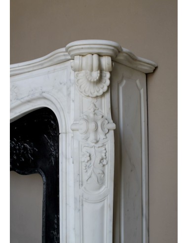 Impressive Baroque antique fireplace in Statuary White marble, featuring elegant floral carvings, and a cast-iron insert.