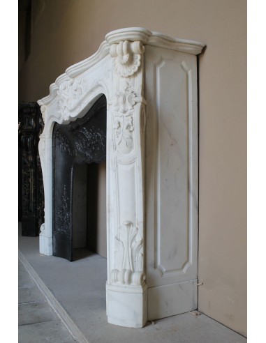 Impressive Baroque antique fireplace in Statuary White marble, featuring elegant floral carvings, and a cast-iron insert.