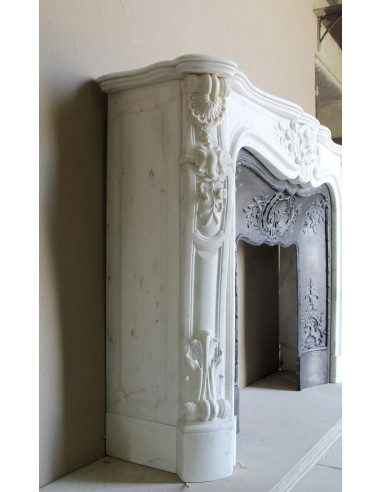 Impressive Baroque antique fireplace in Statuary White marble, featuring elegant floral carvings, and a cast-iron insert.