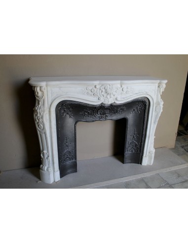 Impressive Baroque antique fireplace in Statuary White marble, featuring elegant floral carvings, and a cast-iron insert.