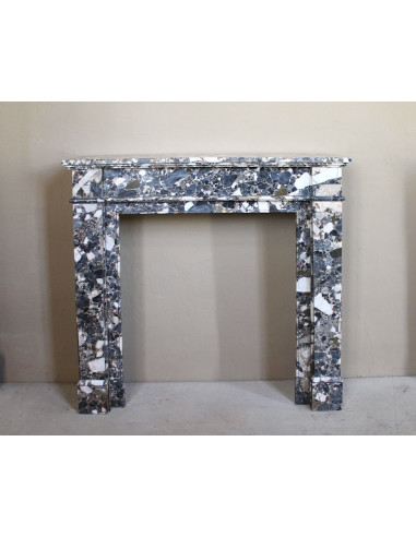 Antique Neoclassical marble fireplace, with minimalist lines and elegant multicolored veining on a dark background.