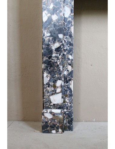 Antique Neoclassical marble fireplace mantel, with minimalist lines and elegant multicolored veining on a dark background.