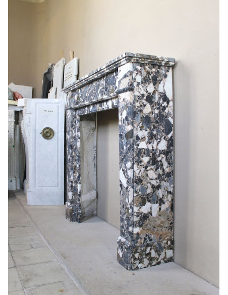 Antique Neoclassical marble fireplace mantel, with minimalist lines and elegant multicolored veining on a dark background.