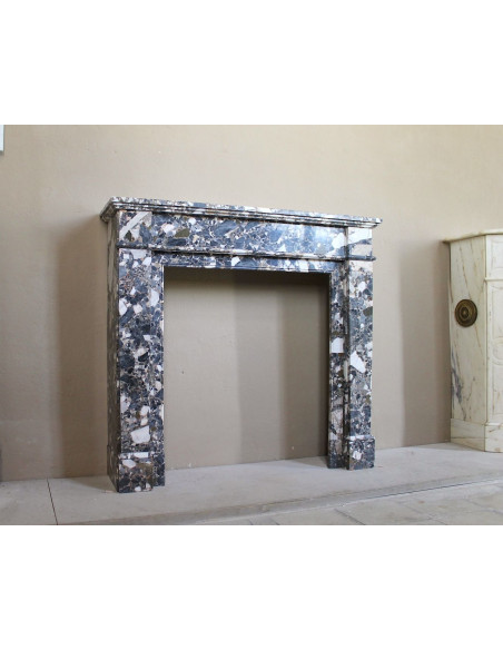 Antique Neoclassical marble fireplace mantel, with minimalist lines and elegant multicolored veining on a dark background.