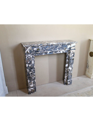 Antique Neoclassical marble fireplace mantel, with minimalist lines and elegant multicolored veining on a dark background.