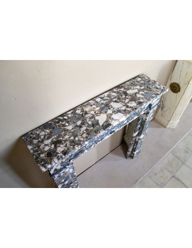 Antique Neoclassical marble fireplace mantel, with minimalist lines and elegant multicolored veining on a dark background.